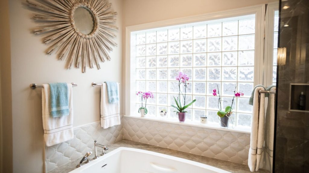 A master bathroom with a tub and two towel holders