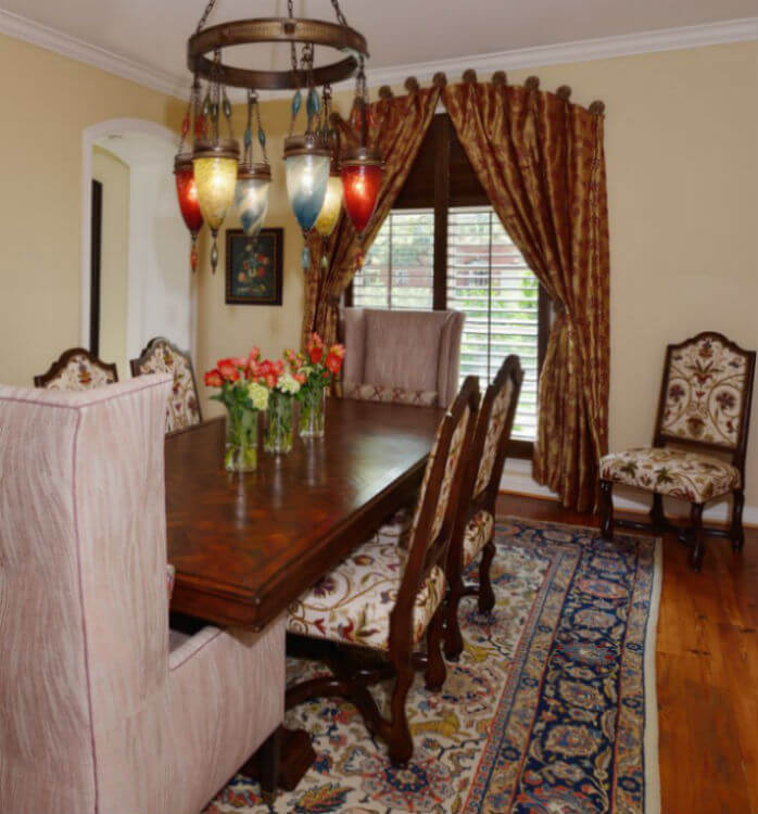 A dining room with a carpet and dark curtains